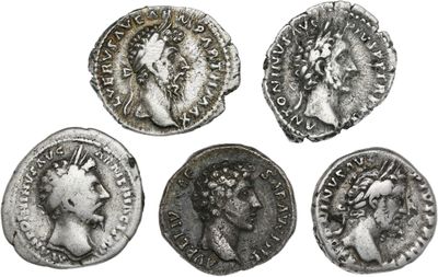 quatre pièces de monnaie romaines anciennes, dont l'une représente la tête d'une femme et une autre une couronne