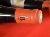 several bottles of wine are lined up on a red surface