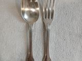 deux cuillères en argent et une fourchette posées sur une nappe blanche