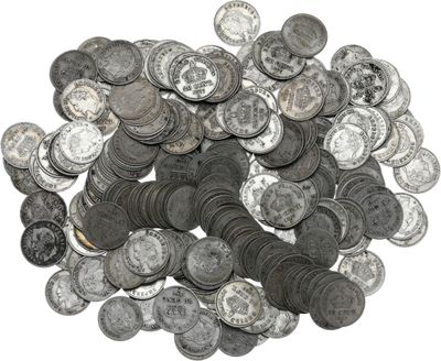 a pile of old silver coins on a white surface