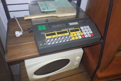 un ordinateur posé sur une étagère à côté d'un micro-ondes