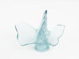 a blue glass butterfly on a white surface