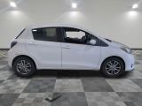 the small white car is parked in a large room