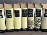 six livres posés sur une table, sur fond gris, avec une photo en noir et blanc