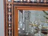 a large mirror with a vase on it and a vase in front of it