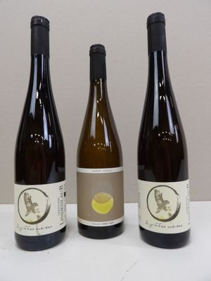 three bottles of wine sitting on a table next to each other