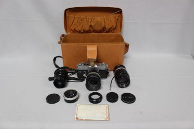 a box with a camera, lens, and other items in it