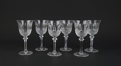 a set of six crystal wine glasses on a black background