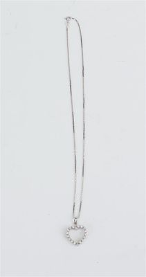 un gros plan d'un collier sur une surface blanche avec un fond blanc
