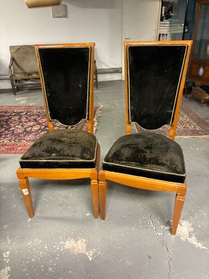 pair of chairs with black velvet upholstered seats in a room