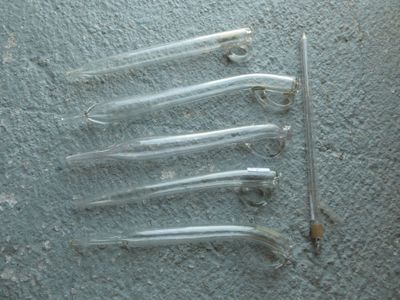 cinq morceaux de plastique par terre, à côté d'une paire de ciseaux