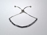silver plated adjustable adjustable bracelet with blue crystals on a white background