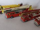 several toy fire trucks are lined up on a white surface