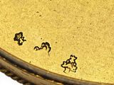 a close up of a gold plate with black writing on it