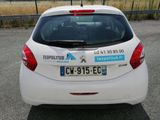 a white car parked in a parking lot with a sign on the back of the car