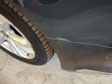 a close up of a car ' s front bumper and tire