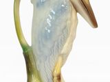 un oiseau perché sur le goulot d'une cruche