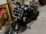 un scooter garé devant un mur orné de dessins