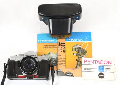 a black camera and some books on a white table