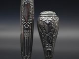 deux vases en argent posés l'un à côté de l'autre sur une table
