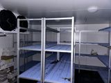 a small room with a lot of shelves and a ceiling fan