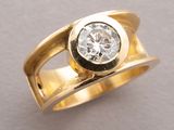 a close up of a gold ring with a diamond on it