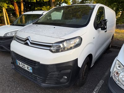 trois fourgonnettes blanches garées sur un parking, avec des arbres en arrière-plan