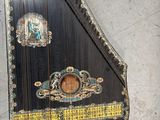 a black and gold musical instrument hanging on the wall