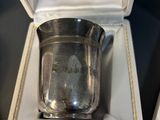 a silver cup sitting in a box on a table