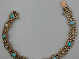 un bracelet en or orné de perles de turquoise et muni d'un fermoir en or