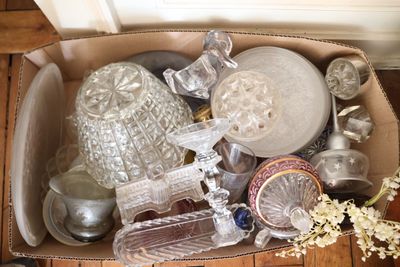 une boîte remplie d'objets en verre posée par terre
