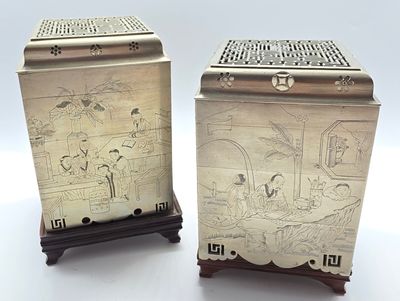 deux boîtes en argent ornées de motifs, posées sur une table