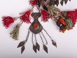 an image of a necklace with a bird made of metal and red tassels