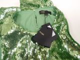 the back of a green sequinned dress with a tag on it