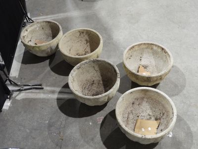 quatre bols en ciment posés par terre les uns à côté des autres