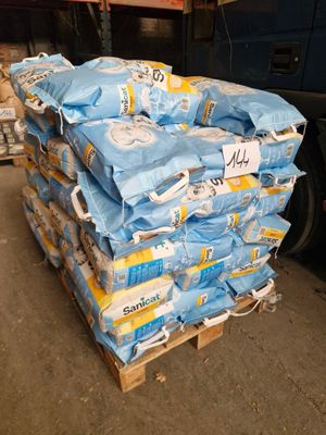 a pile of toilet paper on a pallet next to a truck