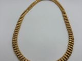 a gold rope necklace on a white background