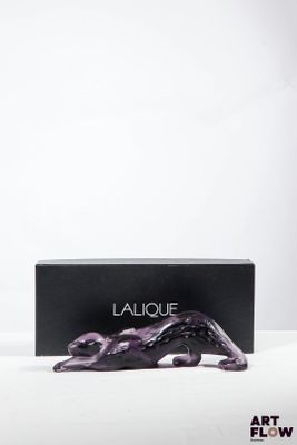 un gros plan d'une boîte noire ornée d'une sculpture violette