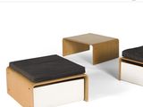 three stools and a table with a black cushion on them