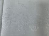 silver fabric with a floral design on a white background