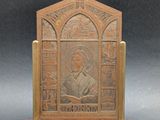 une vieille plaque en bronze sur laquelle figure l'image d'un homme tenant un livre