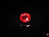 un diamant rouge sur une surface noire