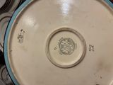 a white plate with a blue rim sitting on a pile of plates