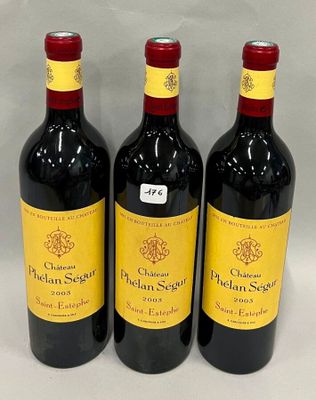 trois bouteilles de vin rouge sont alignées sur une surface blanche