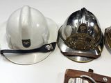 three different types of helmets and a belt on a table