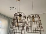 deux lampes suspendues au plafond dans une pièce dotée d'une fenêtre