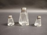 three salt and pepper shakers sitting on a table