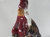 statue of a rooster with a red hat and a red tail