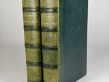 two green books sitting on top of each other on a white surface