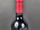 a bottle of red wine with a black and white label on it